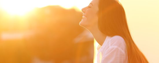 Woman breathing at sunset in a balcony